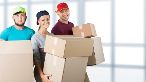 Mover carrying wrapped furniture through a property